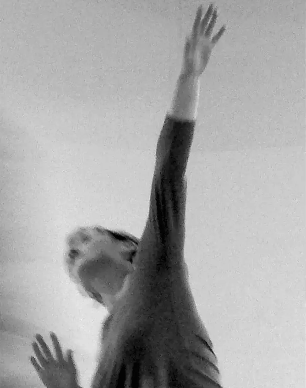 Personne en noir et blanc levant le bras vers le haut