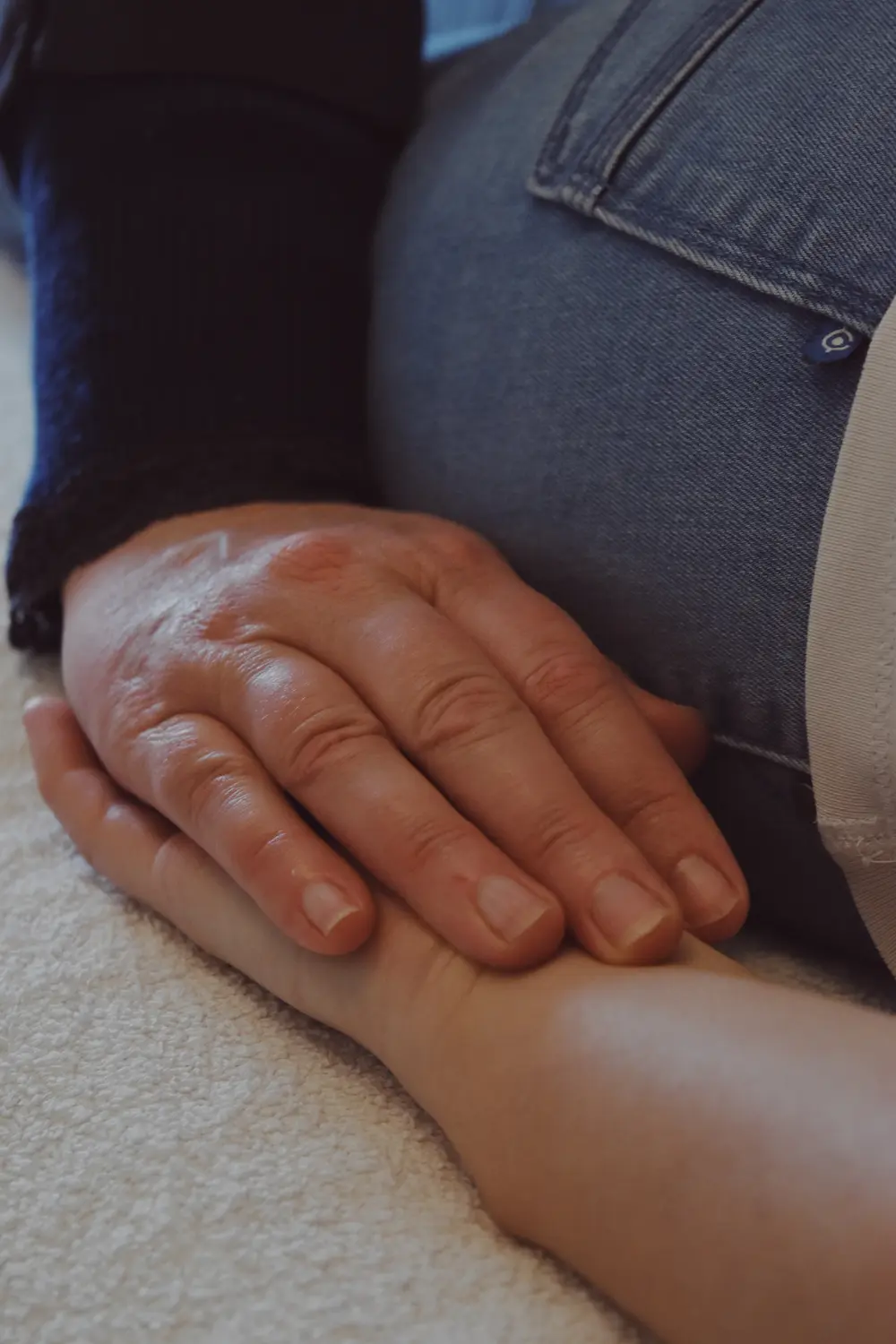 Main du praticien posée sur un bras (gros plan)